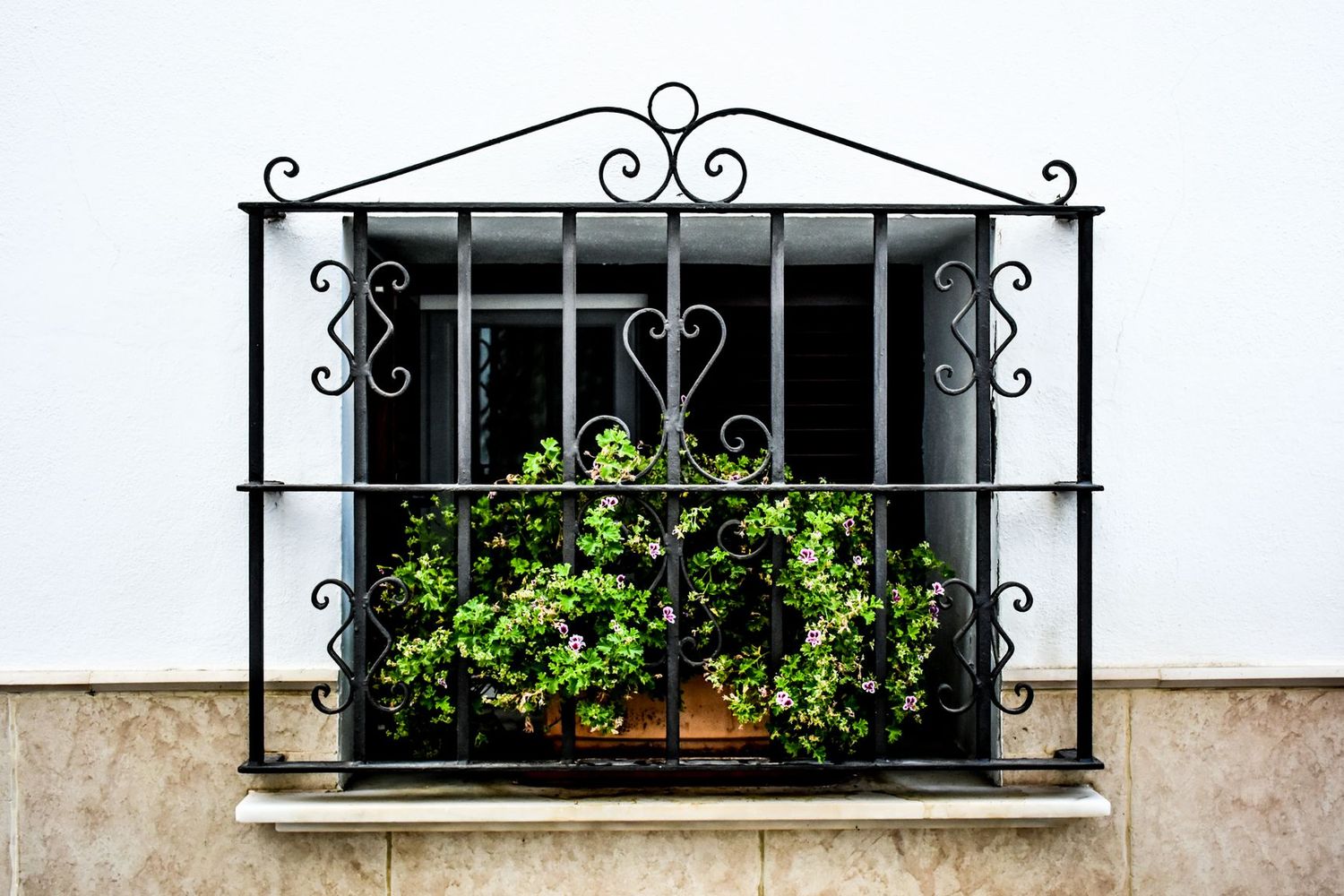 Fachada blanca recién encalada con ventana y reja