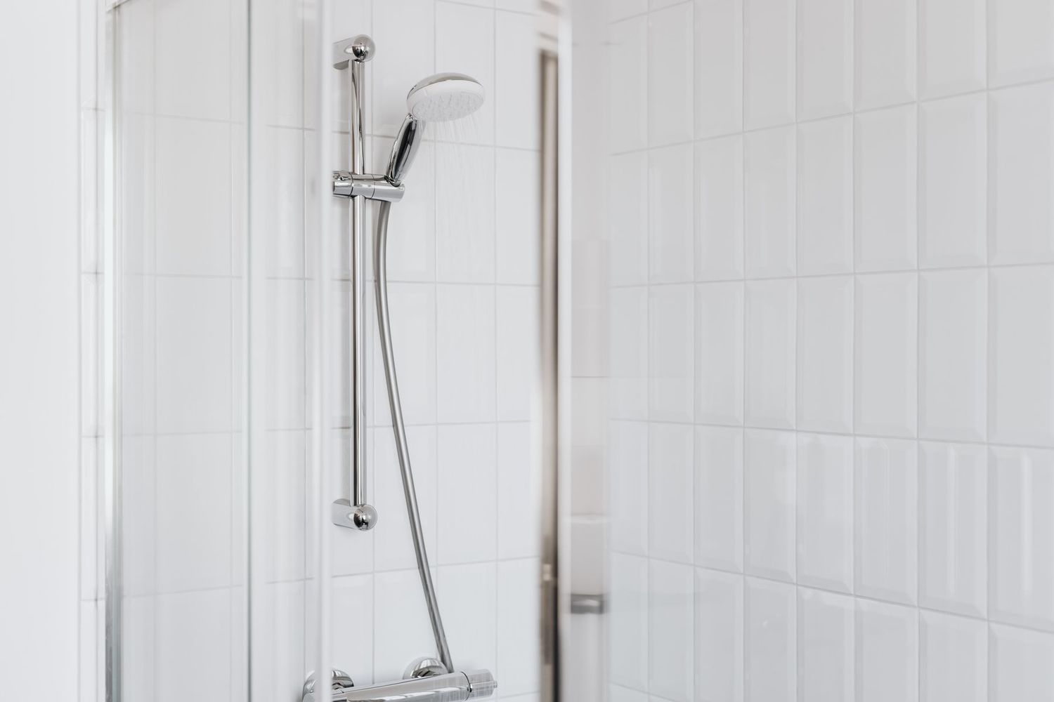 Baño reformado con plato de ducha y azulejo claro