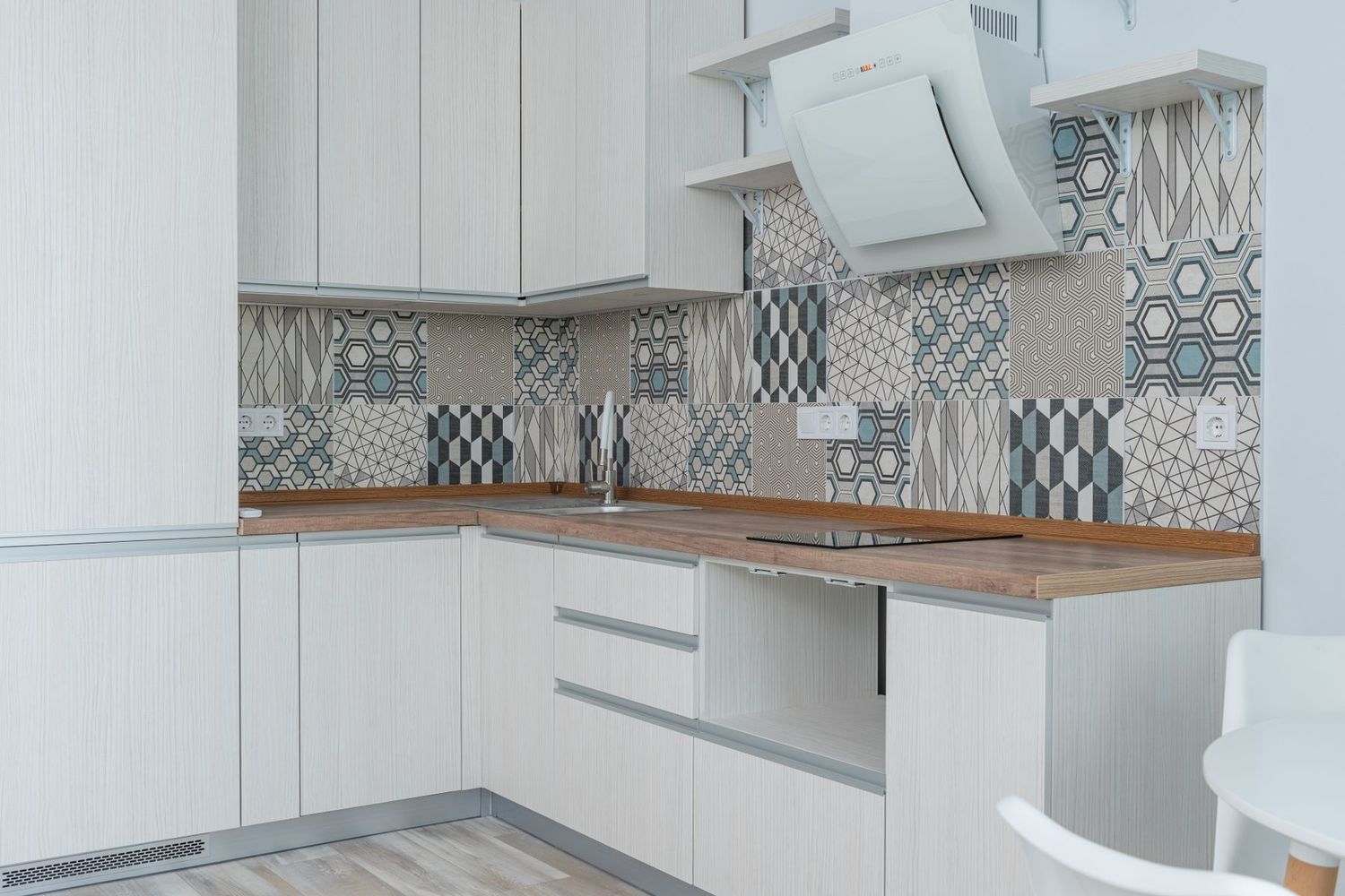 Cocina reformada con muebles blancos y encimera de madera