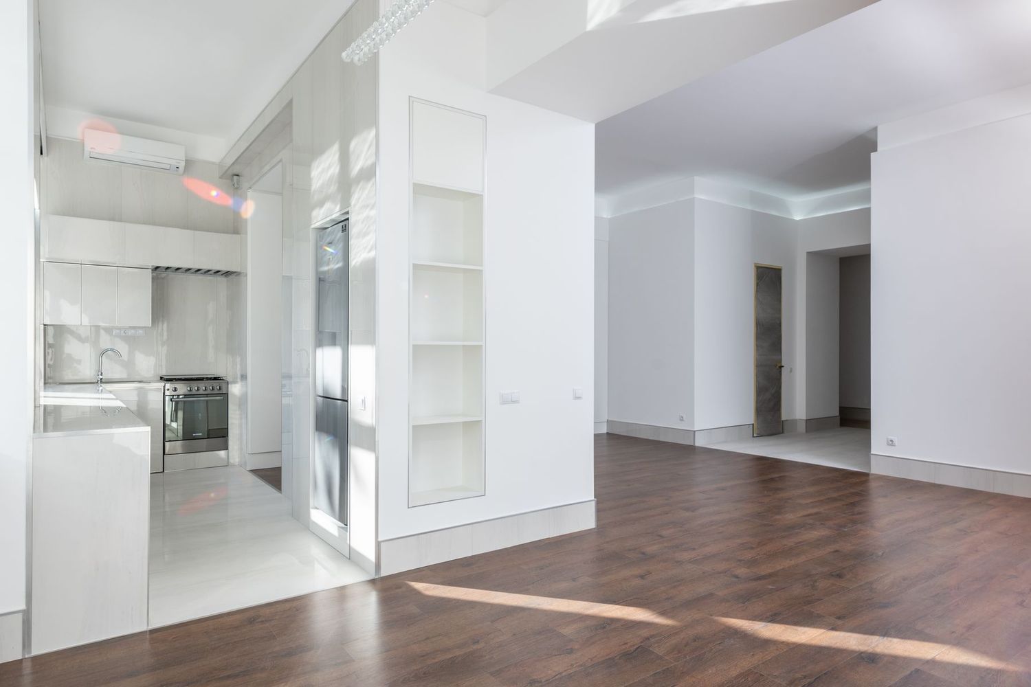 Salón reformado con suelo de madera clara y paredes blancas